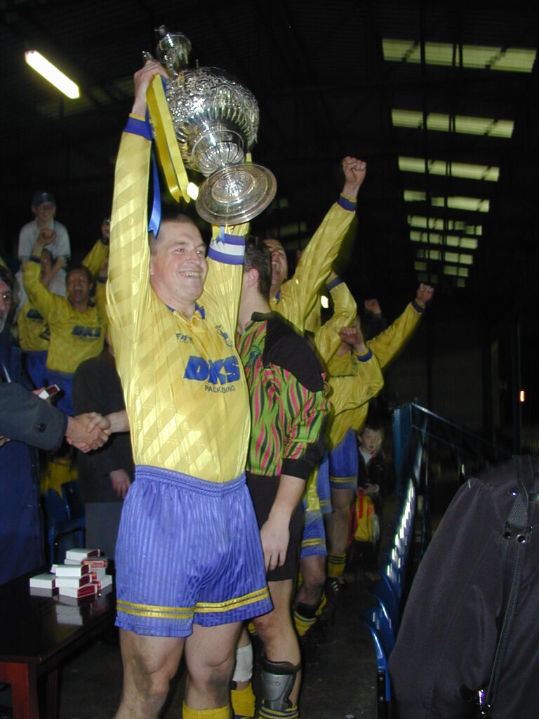 Formby captain Howard Rubbery lifts the NWCFL league cup, 30 April 2001